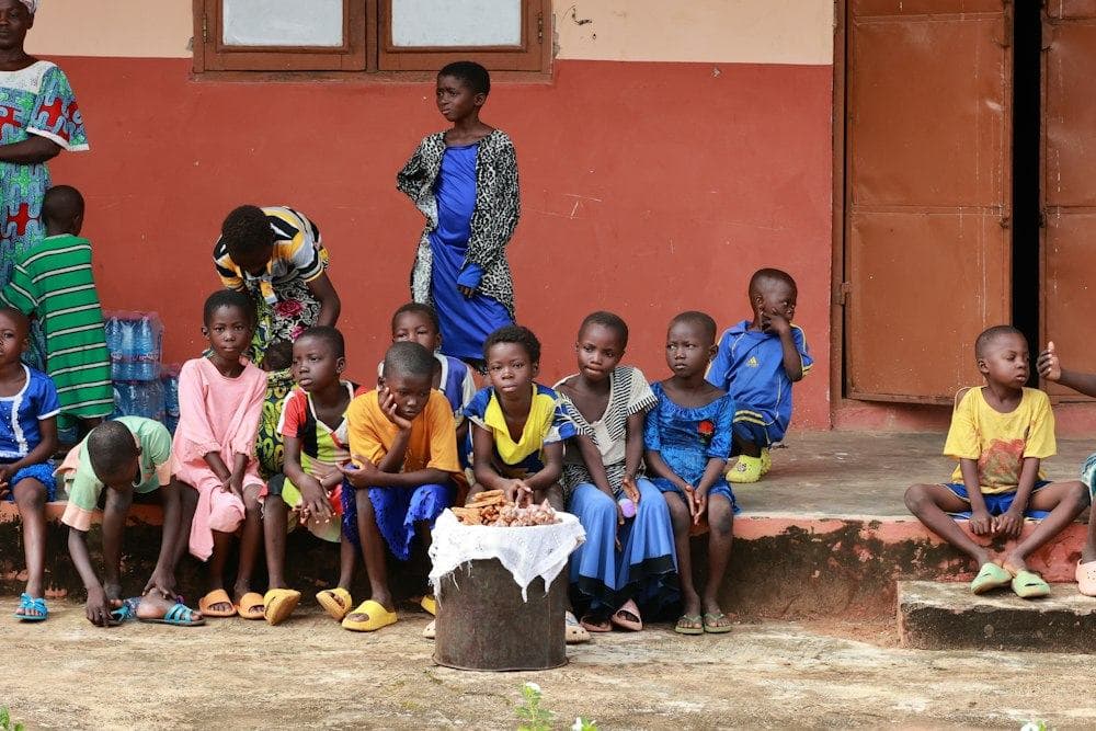 Children sitting together outside a community building